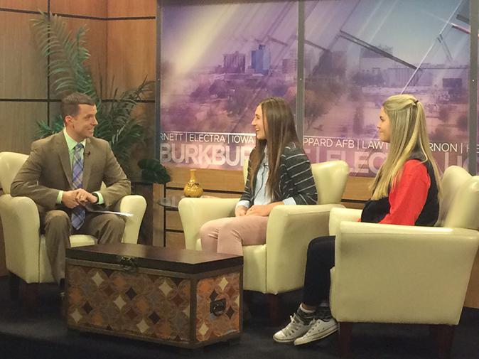 Seniors Morgan Knobloch and Delaney Dickey, an NHS member from Burkburnett High School, promote Harvesting Hope on the morning news. NHS members will be taking orders until Dec. 4.