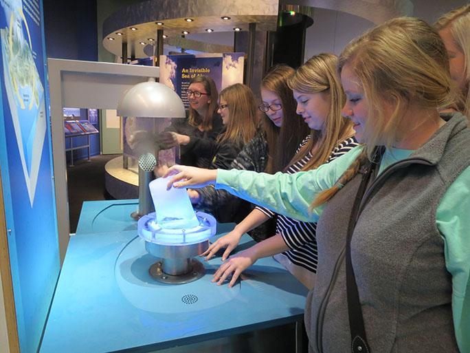 Seniors Sydney Dunkel and Avery Moorehead experiment with ice at the Perot museum alongside sophomores Ashtyn Moorehead, Ashlynn Penny, and Ally Warren.