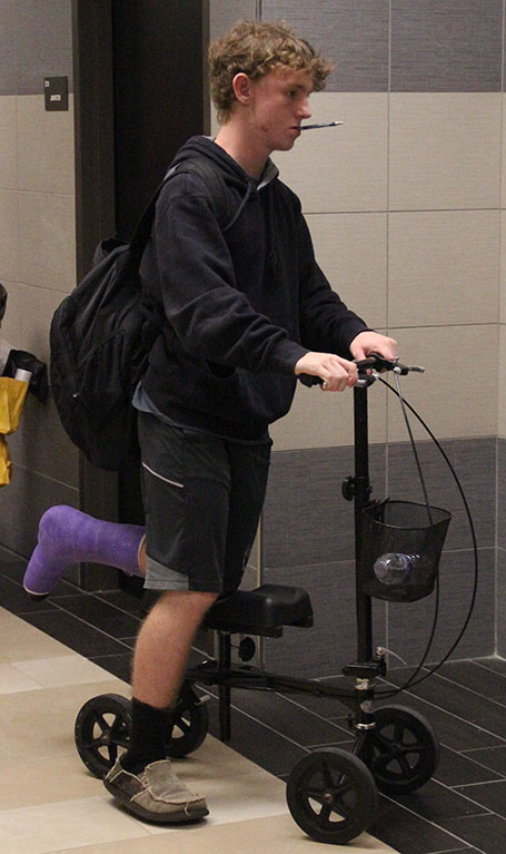 Freshman Jaxton Barrett rides his scooter after breaking his ankle playing basketball.