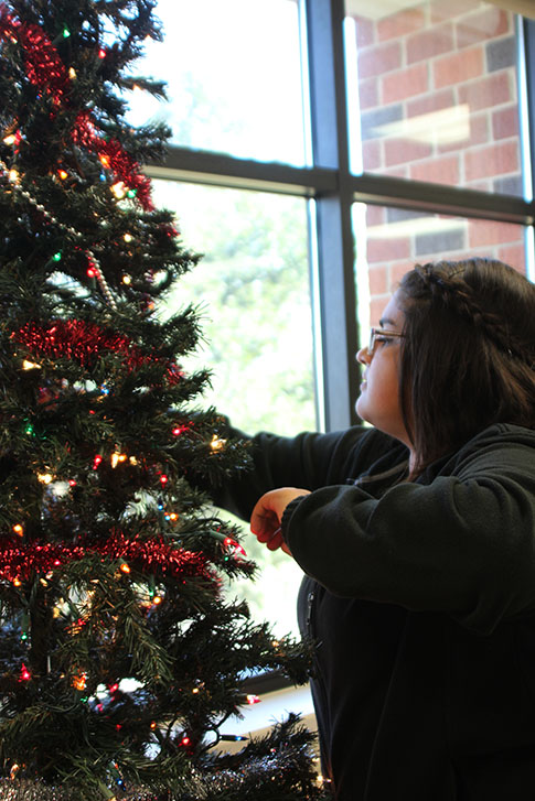 Junior Jesica Crouse helps decorates Ms. Odoms Christmas tree.