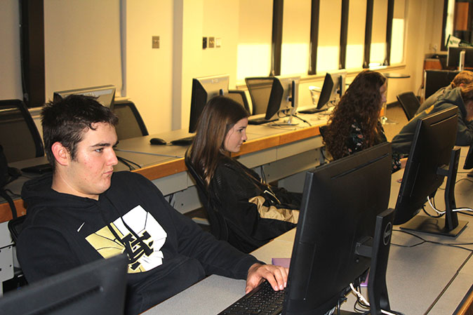 Juniors Jack Herring, Breanna Howard and Avery Williams  work on their college history assignment. for this online, dual credit course, they experience college-level curriculum. 