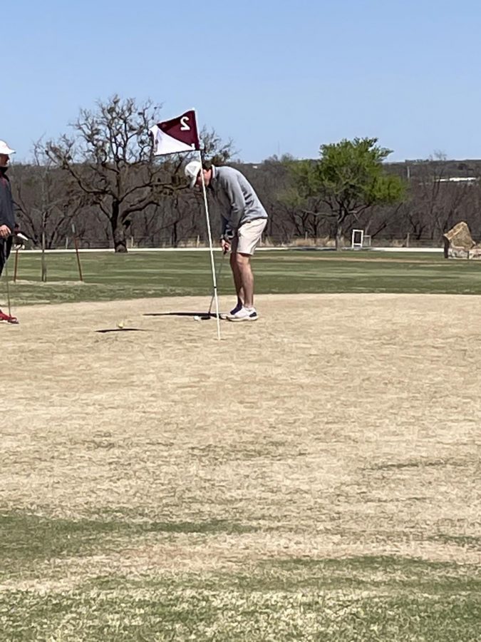 Senior Carter Hilbers putts on the green at district.