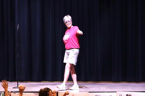 Tonya Mooney, gym instructor, speaks to elementary students during an assembly before her return.