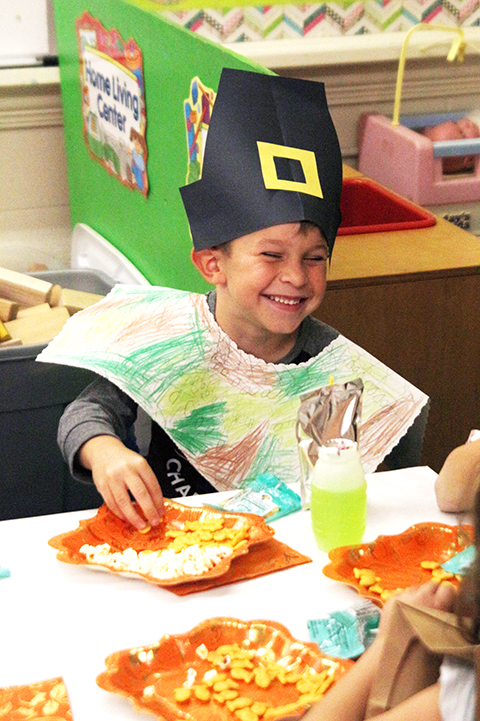 Kindergartner Gage Owen laughs while eating his goldfish snack that resembles fish the Native Americans ate.