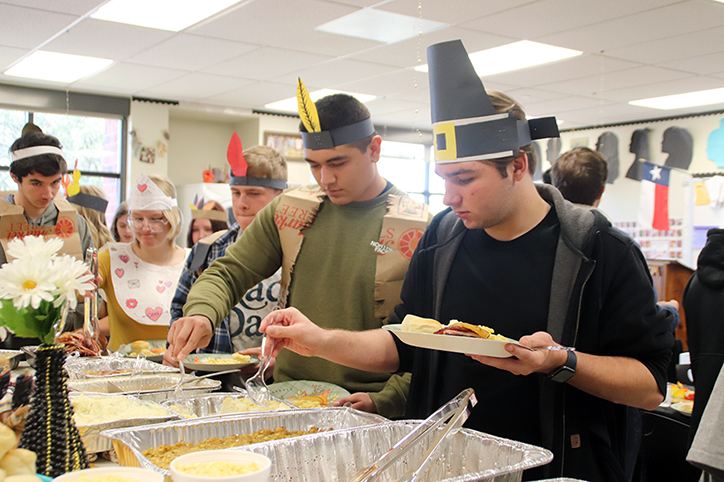Senior Tarin Haney fills up his plate with traditional Thanksgiving foods dressed up as a pilgrim.