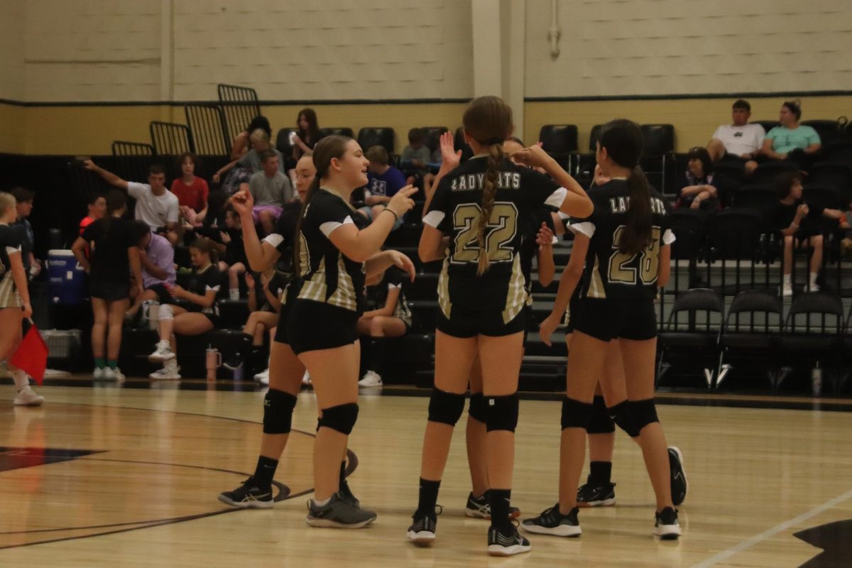 The eighth grade volleyball team celebrates after scoring a point against the Seymour Panthers.