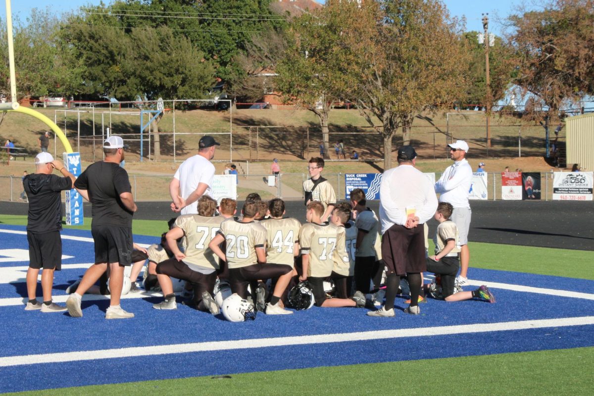 Coach Bradan Ritchey talks with the JH football team before their game at Windthorst