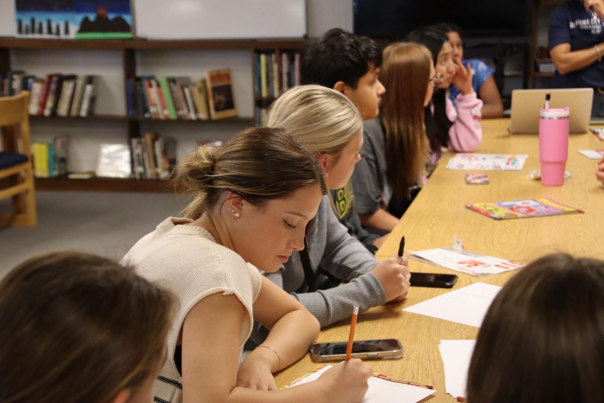 Student Council member Adelyn Harvey helping pick out themes for Red Ribbon week.