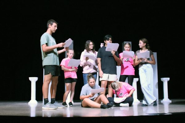 The junior high one-act play cast rehearses a scene.